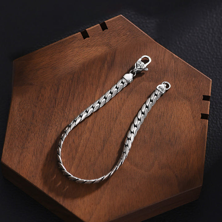 Silbernes Armband Kupfer Energie Stärke auf Holzoberfläche elegant.