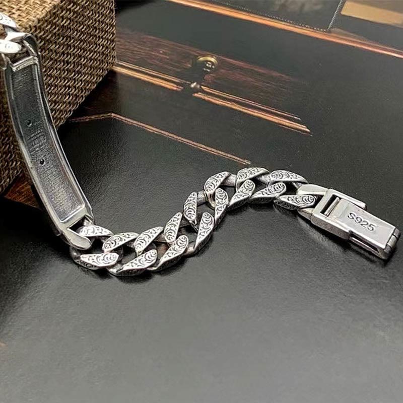 Silbernes Armband mit Kettenglieder-Design auf schwarzem Untergrund.