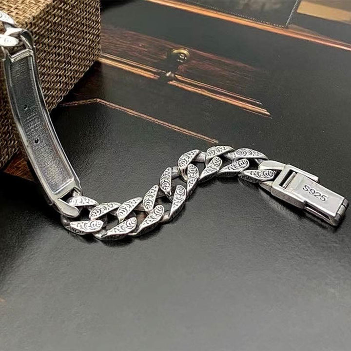 Silbernes Armband mit Kettenglieder-Design auf schwarzem Untergrund.