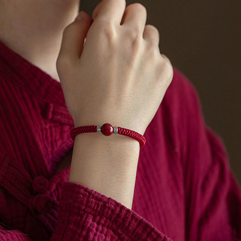 Rotes Zinnober Armband 925 Silber elastisch am Handgelenk getragen.