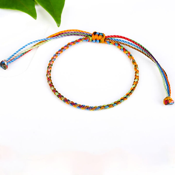 Buntes Glücks-Armband mit Nylonkordeln auf weißem Hintergrund, verstellbar