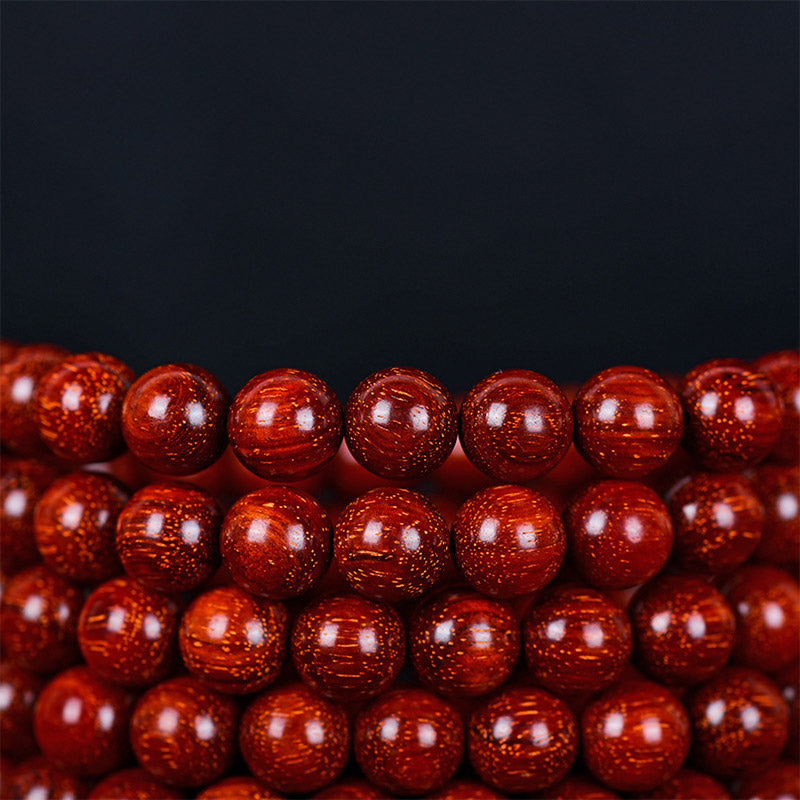 Rotes Sandelholz Armband Perlen Nahaufnahme glänzend Balance Schmuck