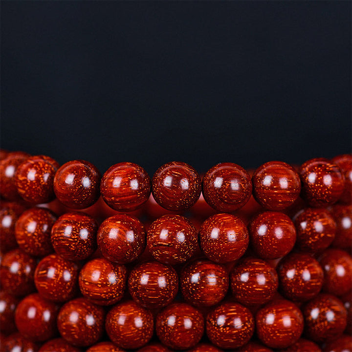 Rotes Sandelholz Armband Perlen Nahaufnahme glänzend Balance Schmuck