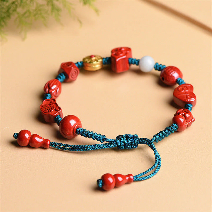 Rotes Zinnober Armband mit blauen Kordeln und goldenen Perlen elegantly.