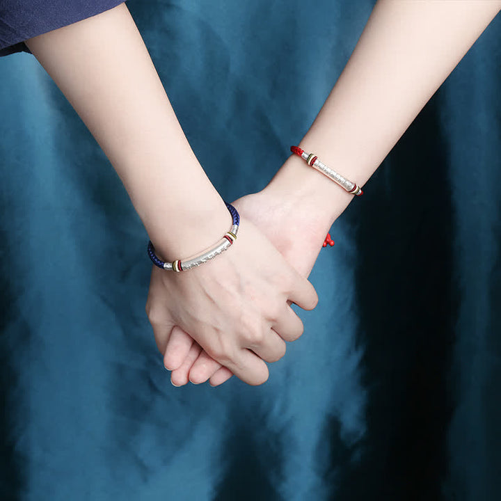 Zwei Personen halten sich an den Händen, tragen farbige Armbänder 925 Silber.