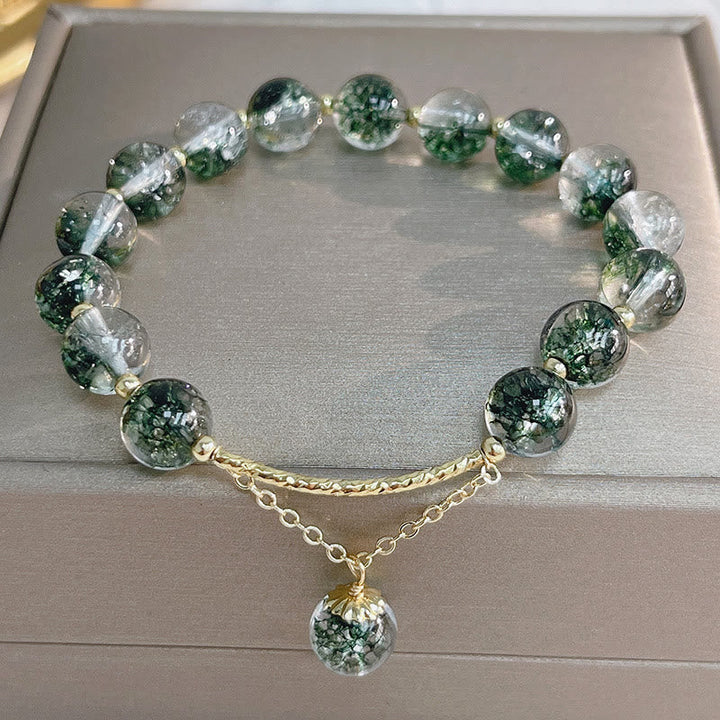 Armband Grün Phantom Kristall Selbstvertrauen auf grauem Untergrund flach fotografiert
