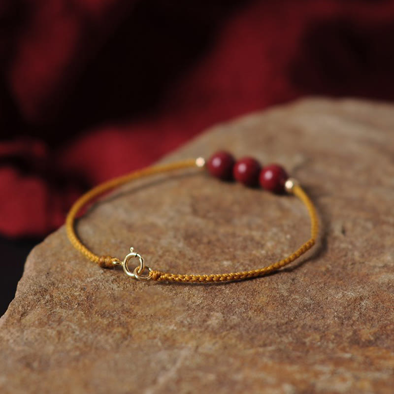 Armband Zinnober – Segen & Segen goldenes Garn rote Perlen elegant