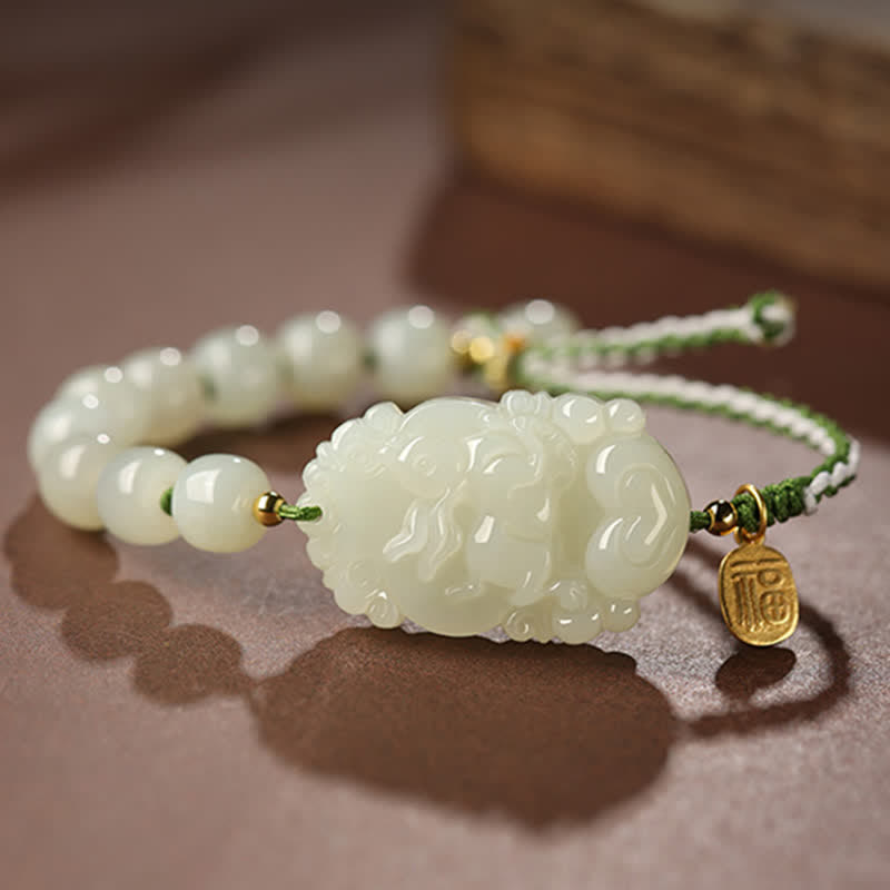 Jadegrünes Armband mit Perlen und goldenem Charm elegant präsentiert.