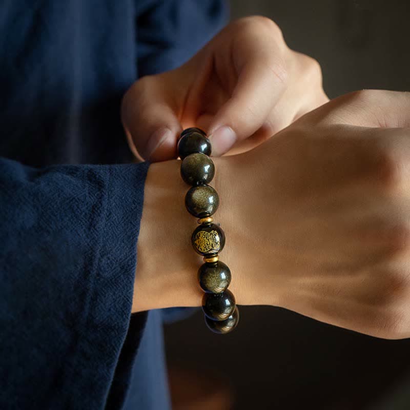 Obsidian Armband mit goldenen Perlen am Handgelenk getragen elegant