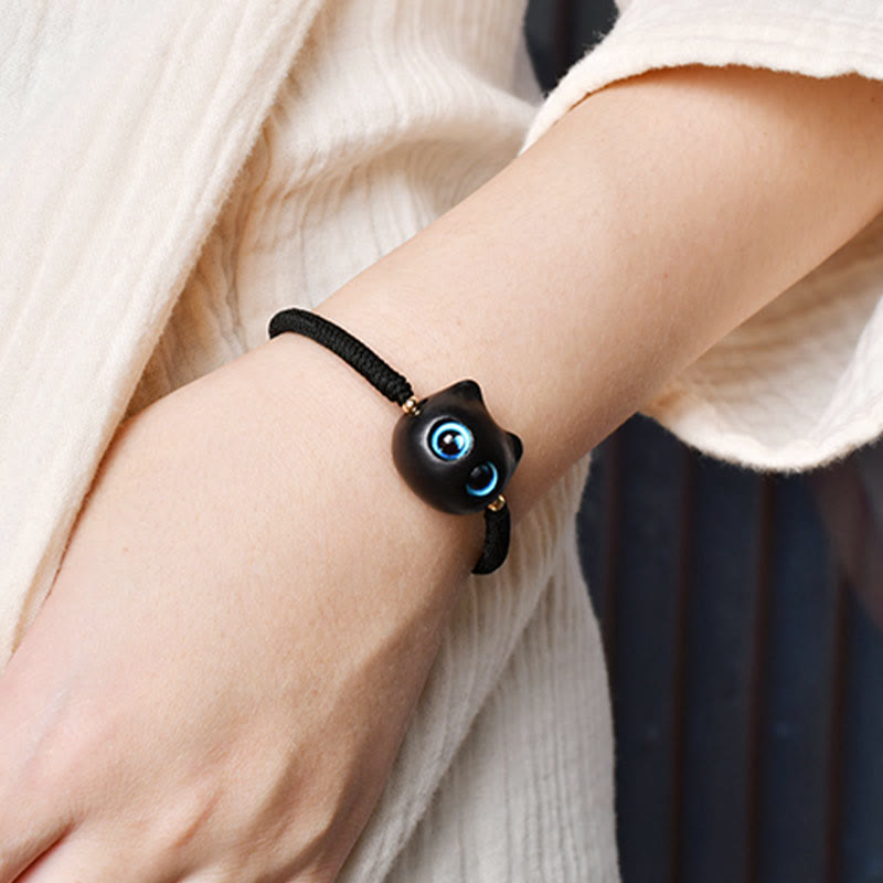 Armband Ebenholz Katze mit blauen Augen am Handgelenk getragen