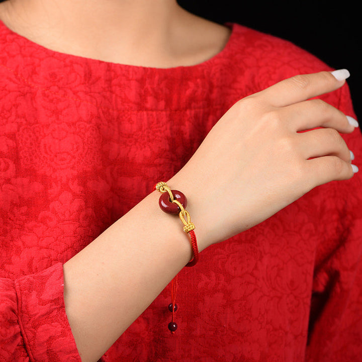 Armband Zinnober Frieden Segen Energie rotes Seidenband goldene Verschlüsse Handgelenk