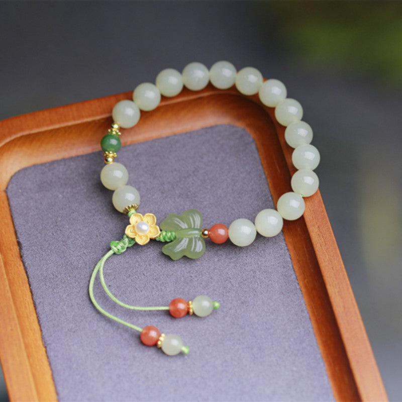 Jade Armband mit Schmetterling, Blume und roten Perlen elastisch.