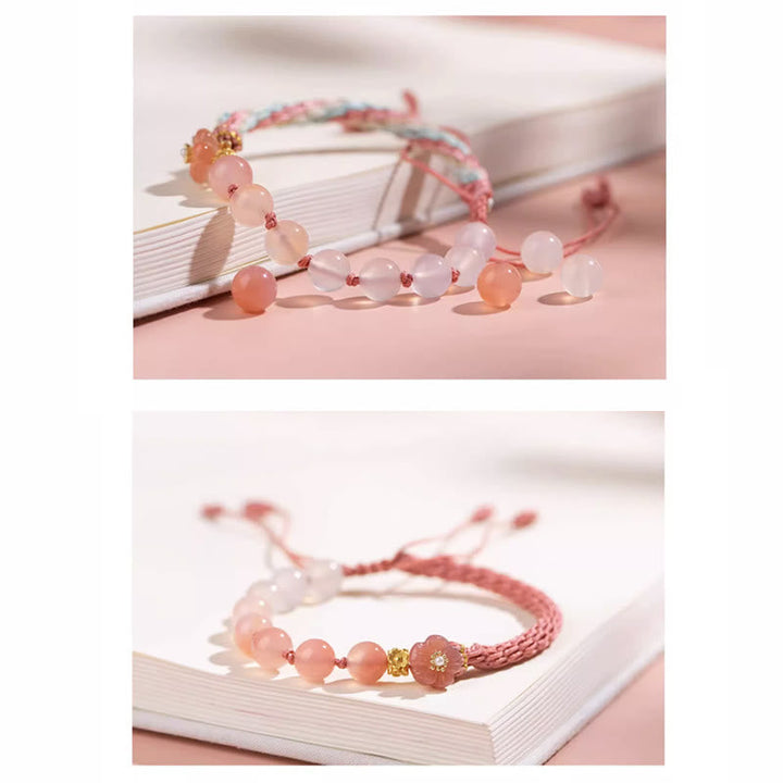 Armband Achat Pfirsichblüte rosé Perlen auf weißem Notizbuch Nahaufnahme