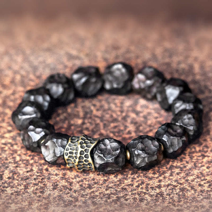 Schwarzes Ebenholz Armband mit Kupfer Perlen auf Naturstein Oberfläche.