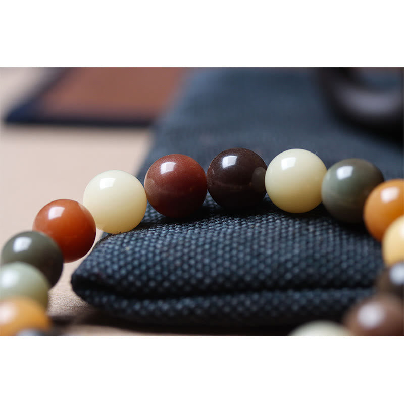 Bodhi Armband mit bunten Perlen auf schwarzem Stoff Nahaufnahme.