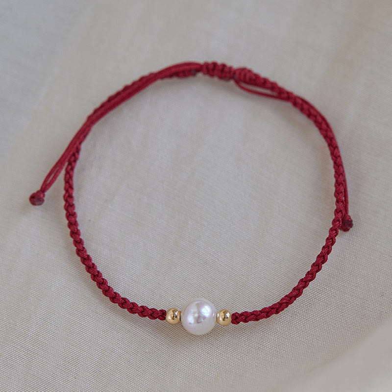 Rotes geflochtenes Armband mit Naturperle und Goldperlen, Glück und Energie.