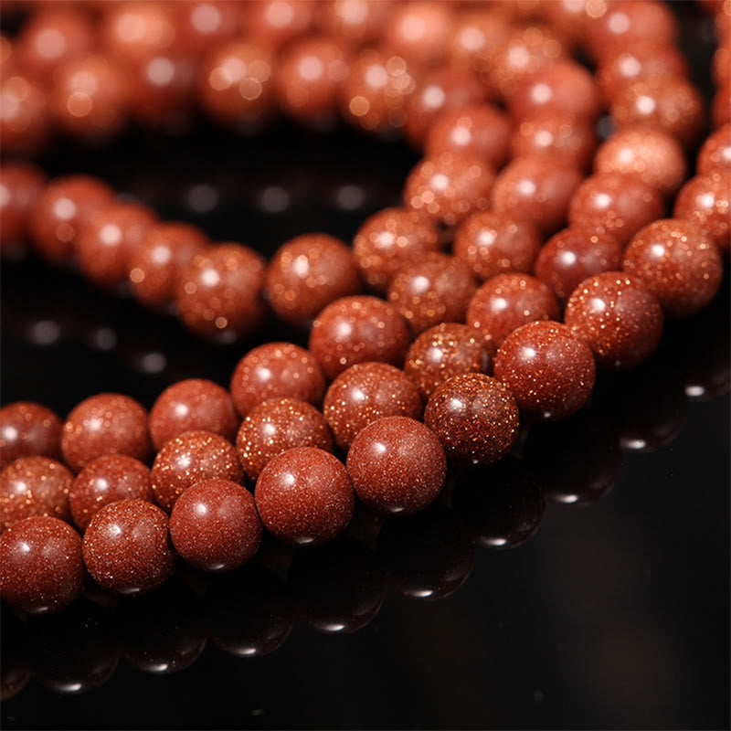 Rotes Glitzer-Armband mit glänzenden Perlen elegant drapiert.