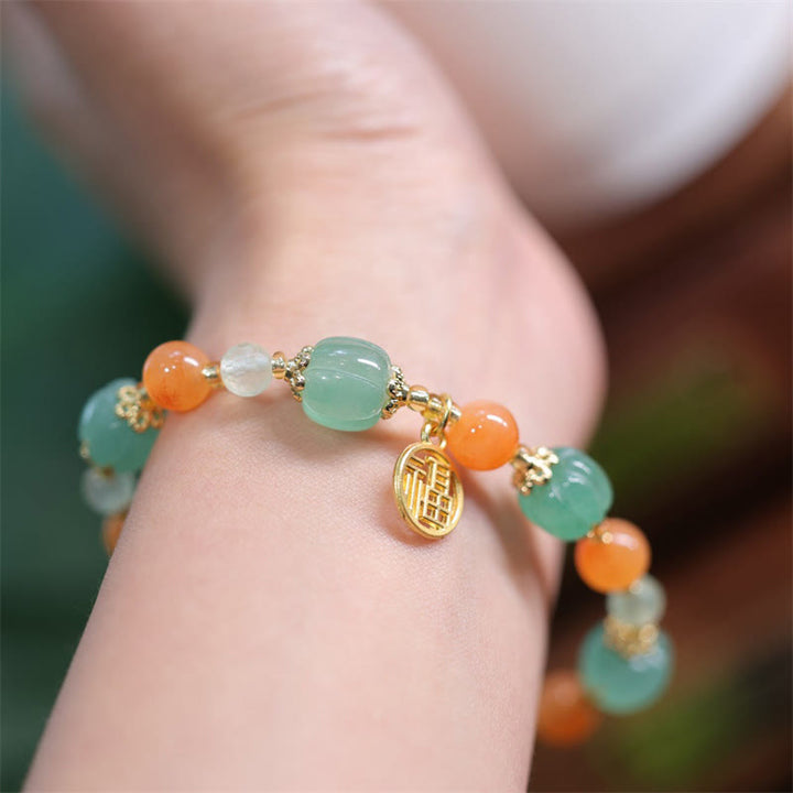 Jade Fu-Zeichen Armband mit grüner Jade und orangenen Achatperlen Handgelenk.