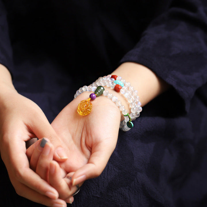 Mondstein Armband mit Lotus Anhänger und bunten Heilsteinen elegant getragen.