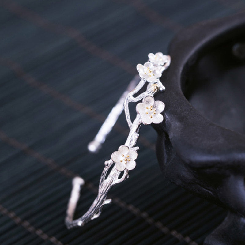Silberarmband mit feinen Blütenanhängern elegant am Handgelenk getragen