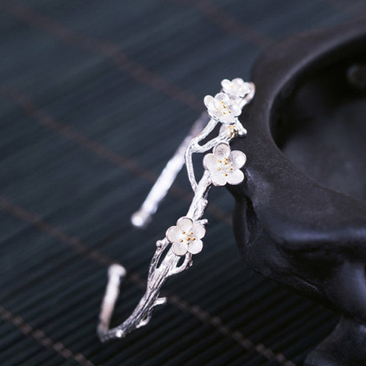 Silberarmband mit feinen Blütenanhängern elegant am Handgelenk getragen