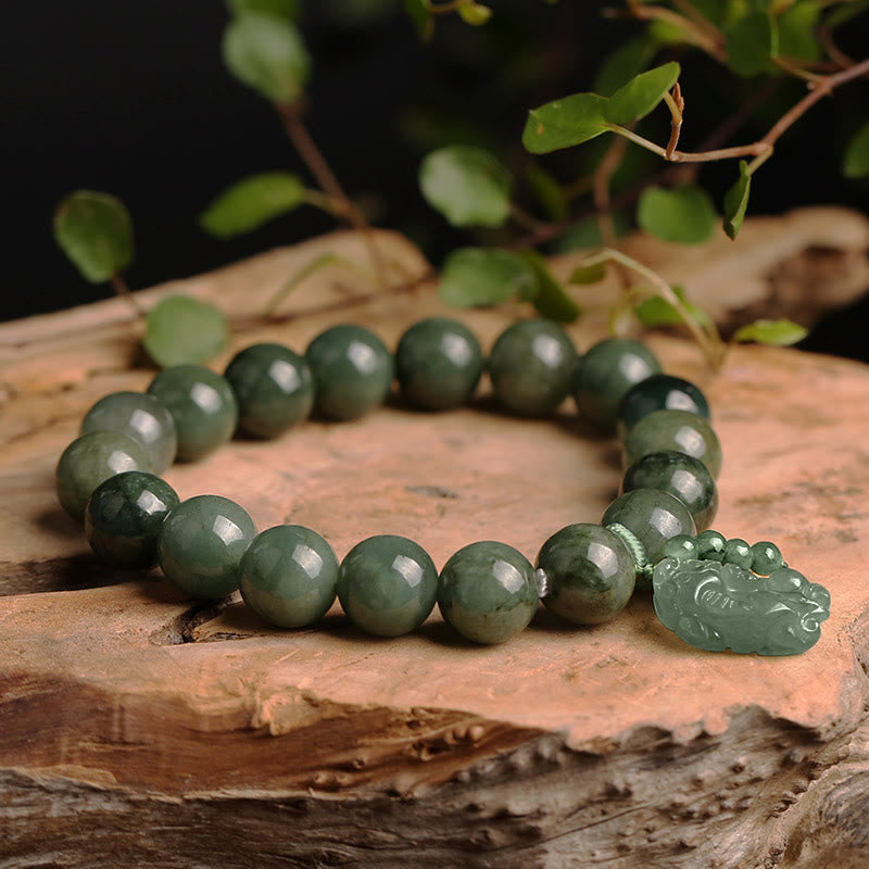 Jade Pixiu Armband mit grünen Perlen auf Holz Natur.