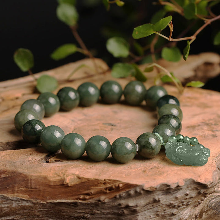 Jade Pixiu Armband mit grünen Perlen auf Holz Natur.