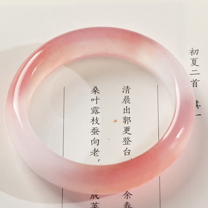 Rosafarbenes Jade Armband Armreif auf weißem Hintergrund mit chinesischem Text