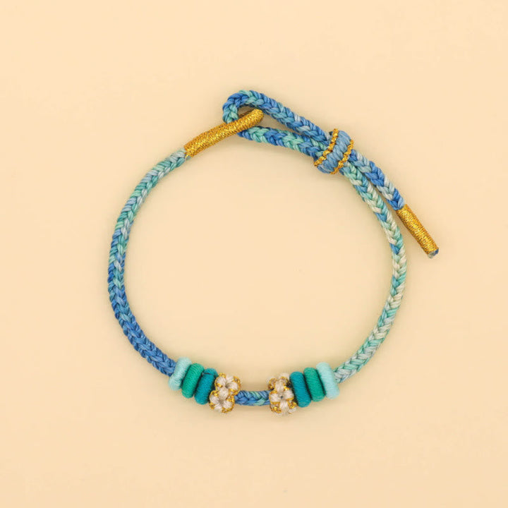 Armband Pfirsichblüte in Blau mit Glücksperlen elastisch verstellbar.