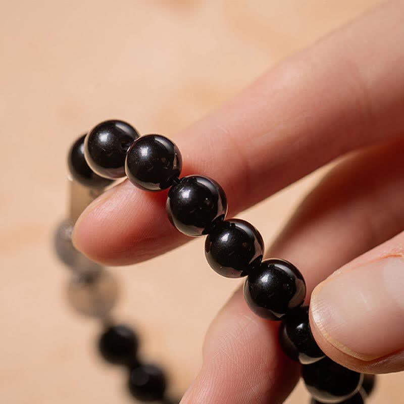 Schwarzes Obsidian Armband Naturstein Perlen elastisch am Handgelenk getragen