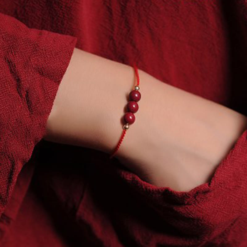 Armband Zinnober – Segen & Segen rotes Perlenarmband am Handgelenk getragen