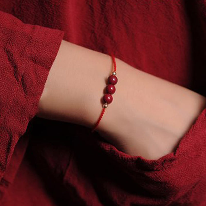 Armband Zinnober – Segen & Segen rotes Perlenarmband am Handgelenk getragen
