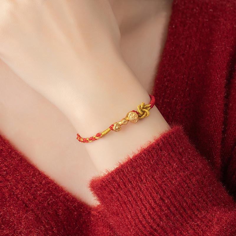 Rotes Armband mit goldenem Fu-Zeichen Glück Energie am Handgelenk getragen
