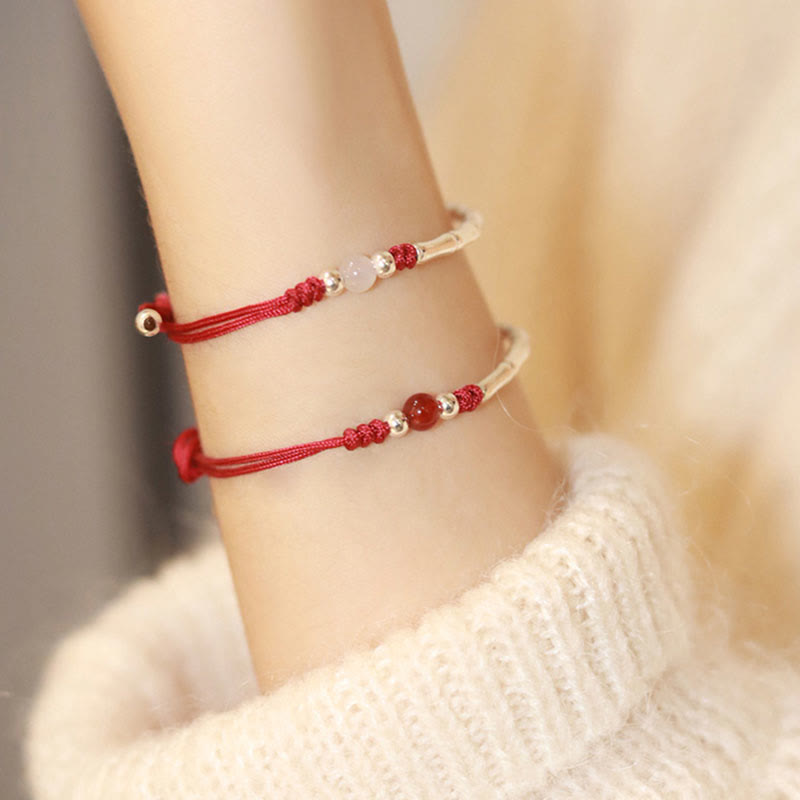 Zwei rote Achatamulett-Armbänder am Handgelenk getragen, elastisch.