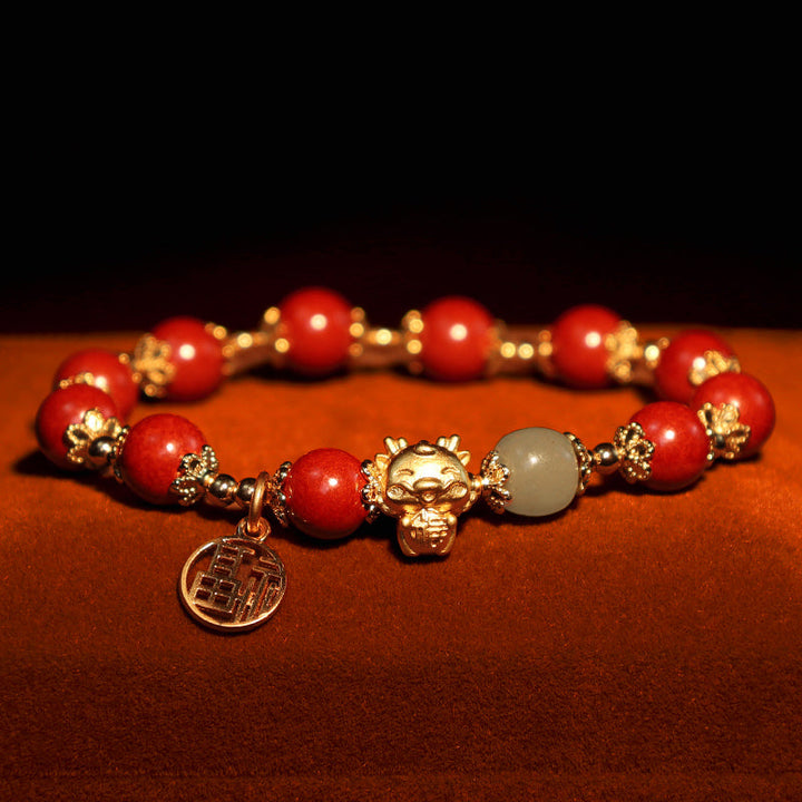 Rotes Armband mit Goldperlen, Pixiu-Anhänger und grauem Stein.