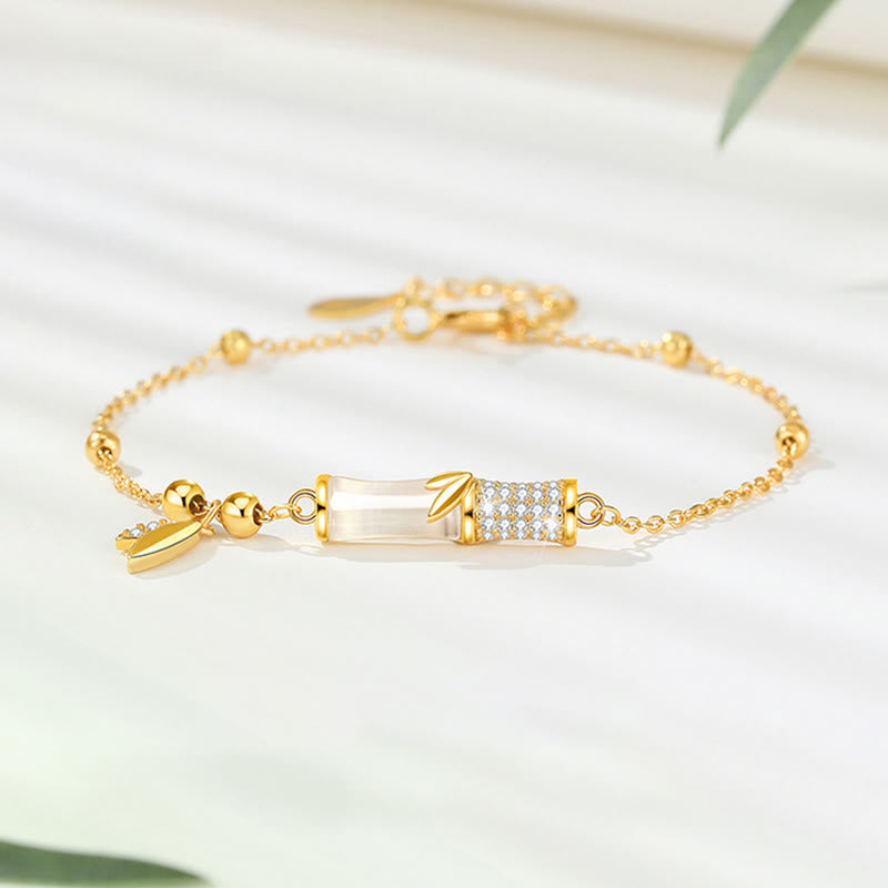 Goldenes Armband mit weißer Jade und Bambus-Design elegant präsentiert.