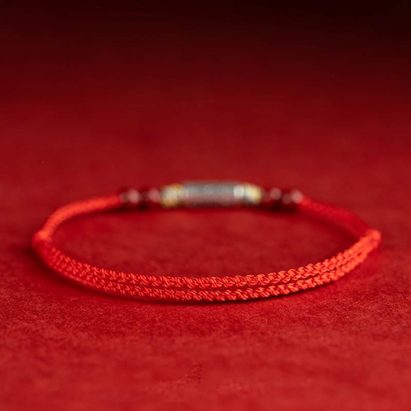 Rotes Seidenfaden Armband mit Metallperlen auf rotem Hintergrund elegante Ausführung