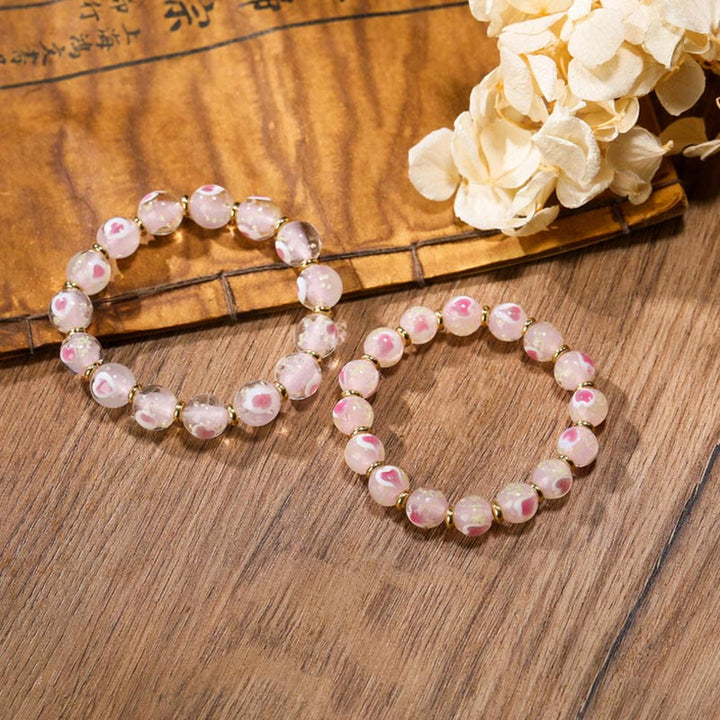 Rosenquarz Armband – Liebe & Segen mit rosa Perlen Holzoberfläche