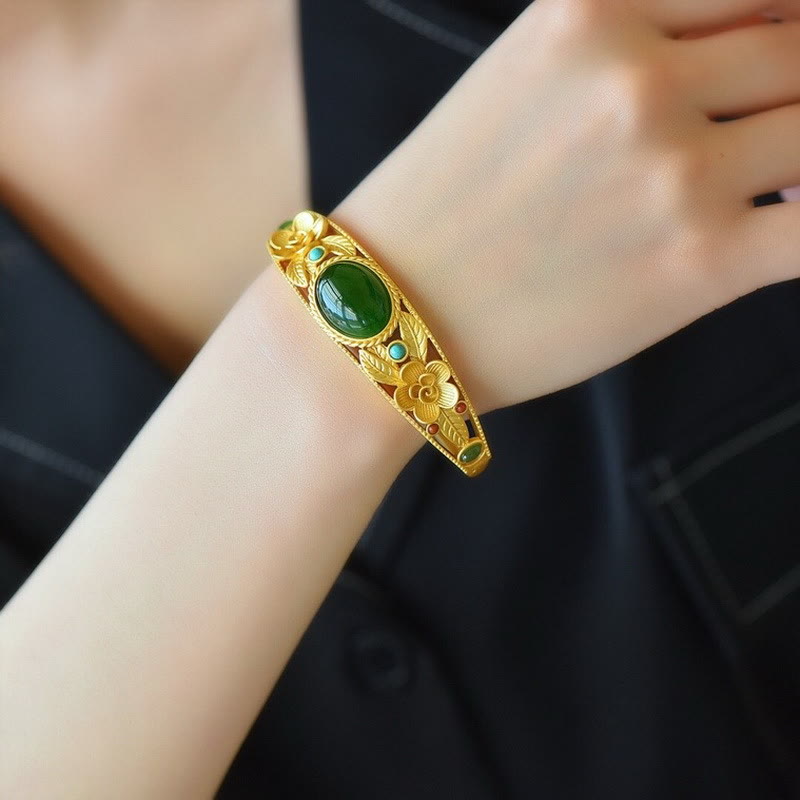 Goldenes Armband mit grüner Jade am Handgelenk elegant getragen.