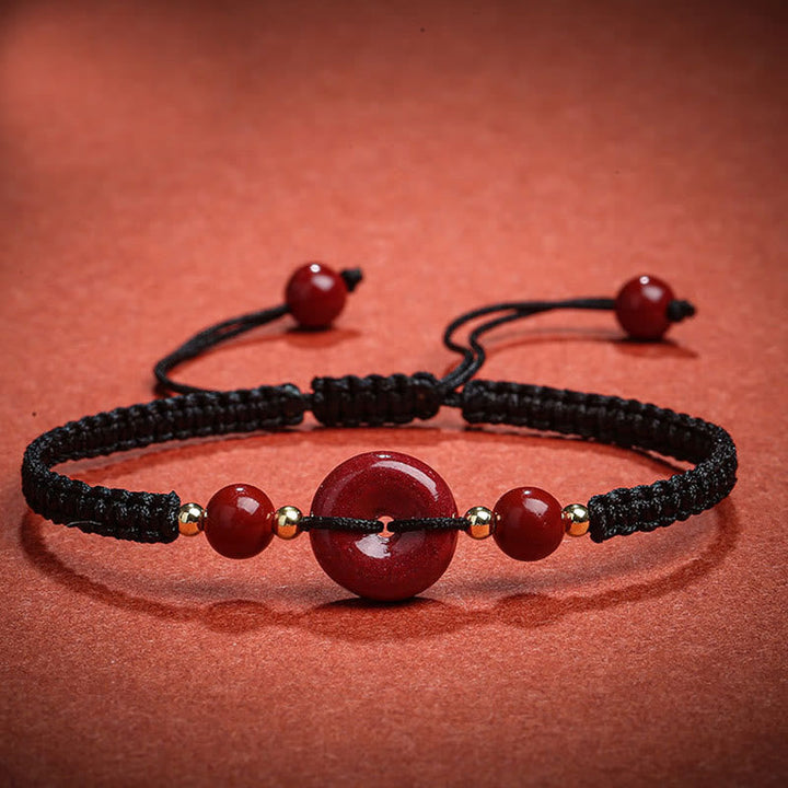Armband Zinnober – Frieden & Segen mit schwarzem elastischem Seidenband.