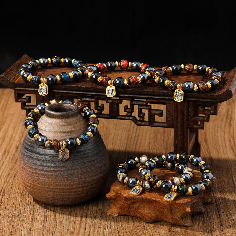 Armband Zakiram mit schwarzen Perlen und Glücksbringern elegant präsentiert.
