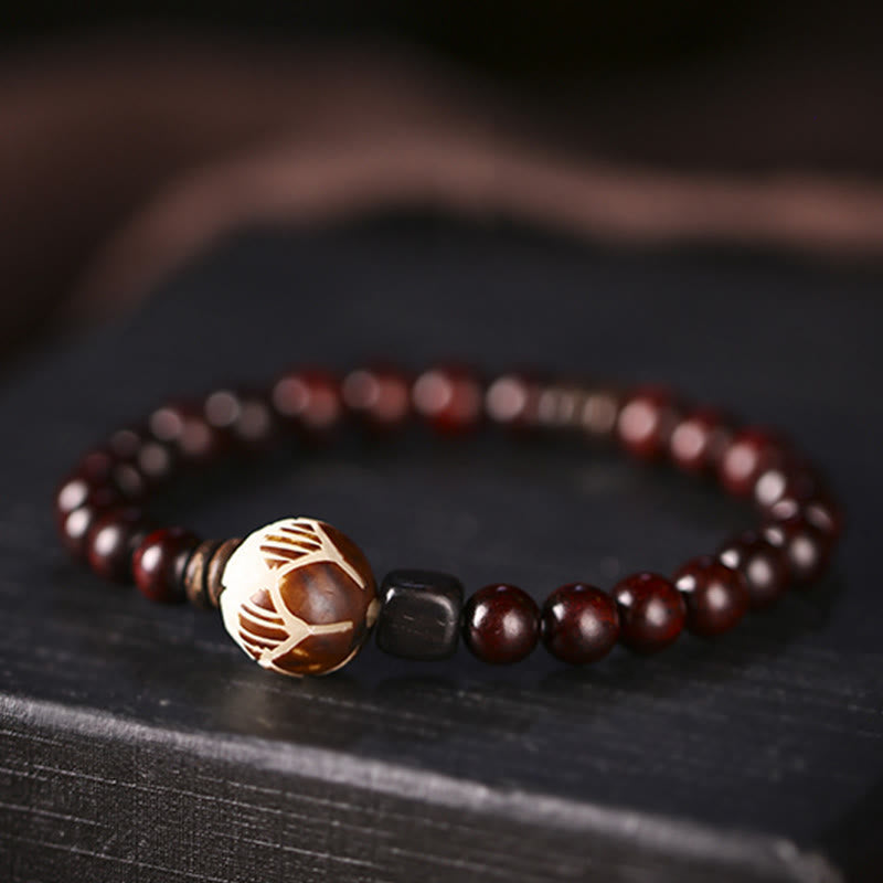 Sandelholz Bodhi Lotus Armband mit roten Perlen elegant getragen