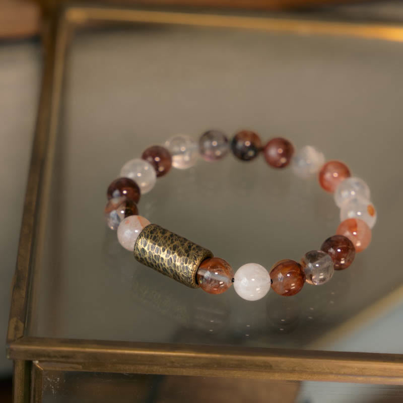 Armband Weißer Kristall – Schutz mit braunen Perlen und Metallzylinder.