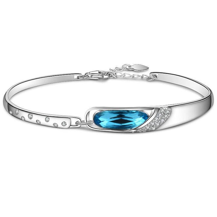 Silbernes Armband mit blauem Kristall und Diamanten, elegantes Design.