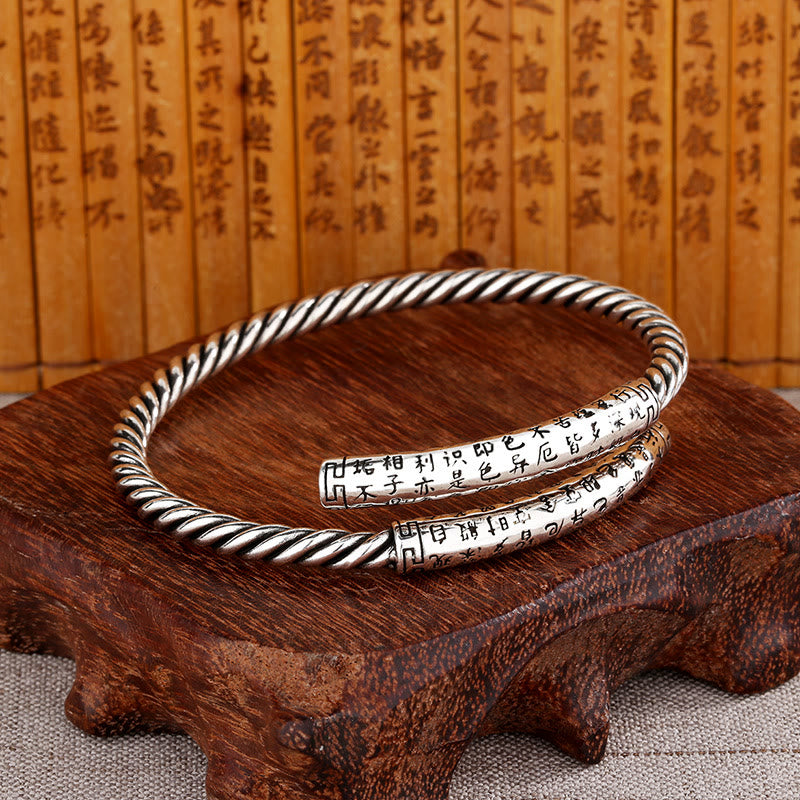 Silbernes Armband Herzsutra Balance mit Gravur auf Holz.