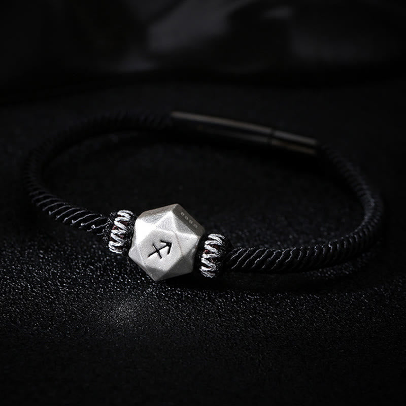 Silberarmband mit Rune am Handgelenk, schwarzes elastisches Armband getragen