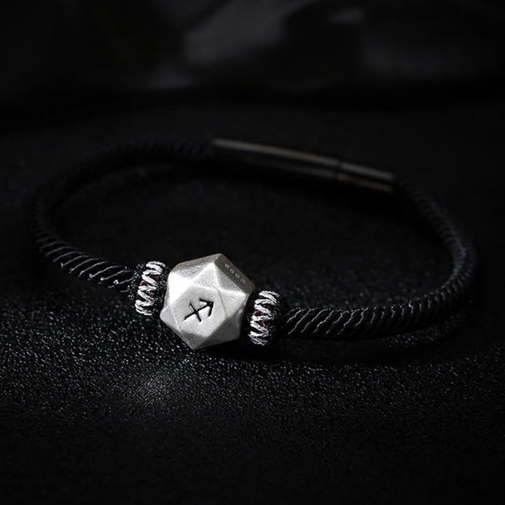Silberarmband mit Rune am Handgelenk, schwarzes elastisches Armband getragen