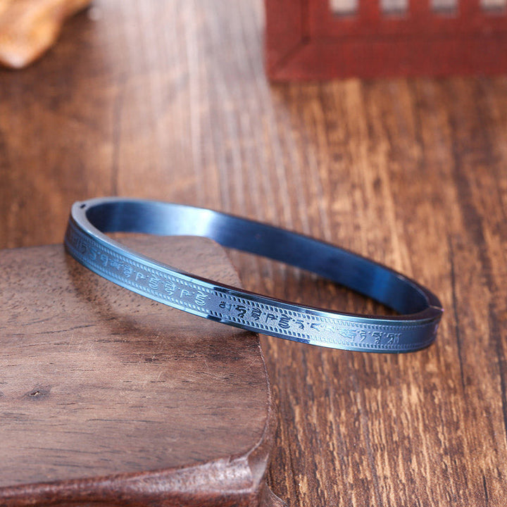 Titanstahl Armband mit Segen Gravur auf Holzoberfläche elegant.