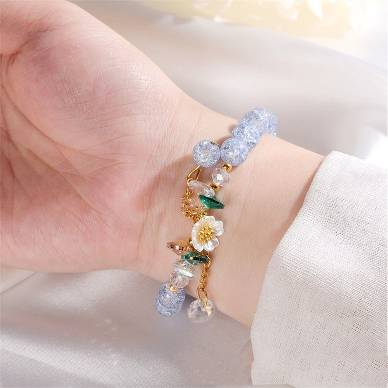 Armband Blume Glas mit blauen Perlen und weißer Blüte elegant getragen