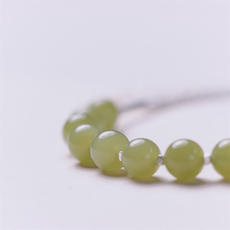 Grünes Jade Armband mit glänzenden Perlen auf weißem Hintergrund elegant